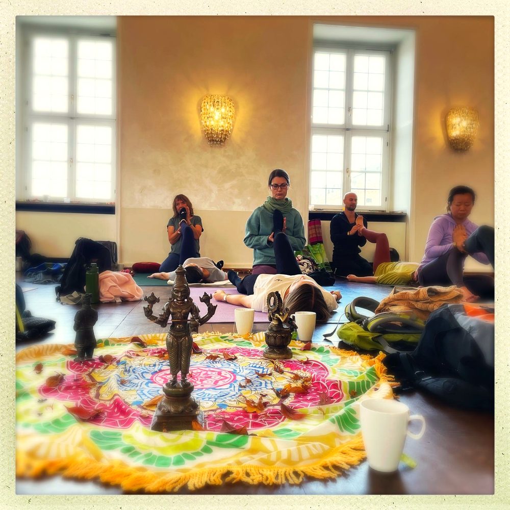 Blumenmandala mit Teilnehmenden im Saal