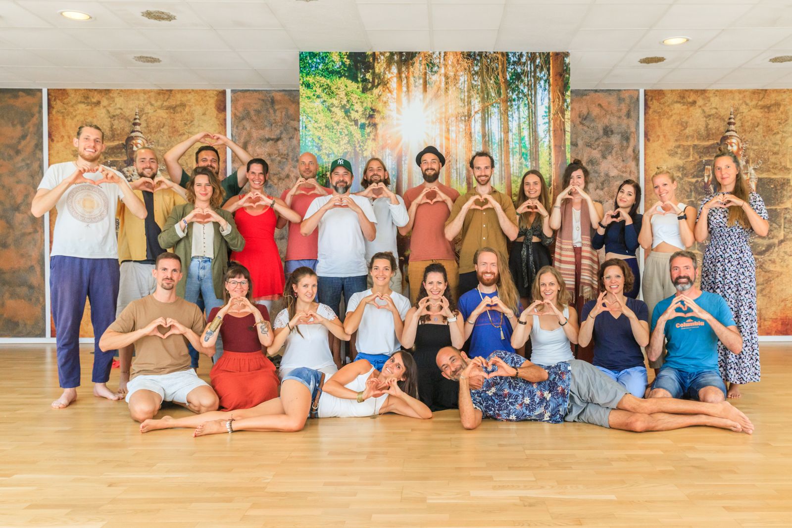 Das Team der Glücksbringer formt mit den Händen Herzen im Yogacenter